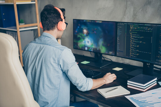 Rear back behind view of his he nice focused skilled experienced guy geek practicing web development dev playing game coding at modern industrial home office work place station indoors