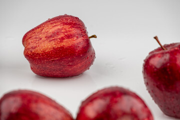 Close up of pile of red apple with clear water drop on 
shell surface texture pattern isolated, white background