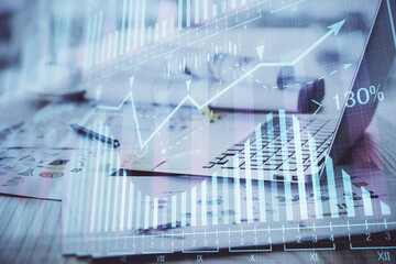 Stock market chart hologram drawn on personal computer background. Multi exposure. Concept of...