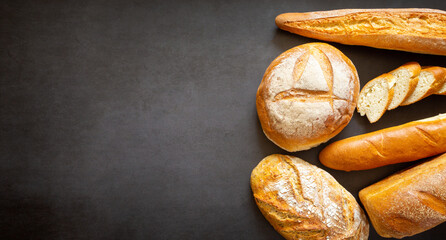 Assorted loaves, baguettes and slices of homemade artisan bread. With copy space and space for text, banner