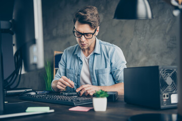 Portrait of his he nice attractive focused skilled guy geek repairing circuit detail motherboard...