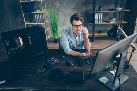 Portrait of his he nice attractive focused skilled guy geek technician repairing hardware calling client supply detail manager at modern loft industrial home office workplace workstation