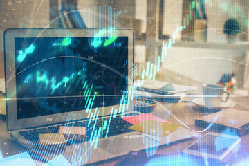 Financial graph colorful drawing and table with computer on background. Multi exposure. Concept of international markets.