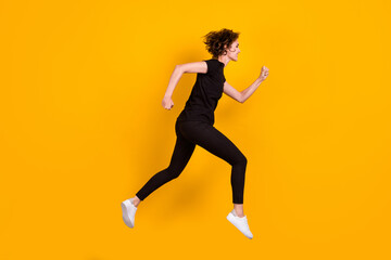 Fototapeta na wymiar Full length body size profile side view of nice cheery thin girl jumping running fast isolated bright yellow color background