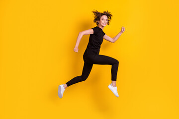 Fototapeta na wymiar Full length body size profile side view of lovely cheerful slender girl jumping running fast isolated bright yellow color background