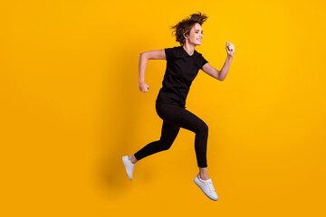 Fototapeta na wymiar Full length body size profile side view of attractive motivated cheerful thin girl jumping running active isolated bright yellow color background