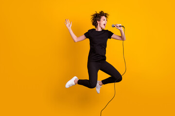 Full length body size view of skinny overjoyed cheery funky girl jumping singing single isolated bright yellow color background