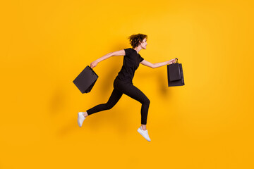 Fototapeta na wymiar Full length body size view of attractive cheerful skinny girl jumping running carrying packages isolated bright yellow color background