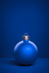 Light blue round matt Christmas ball. Christmas ornament standing on blue background.