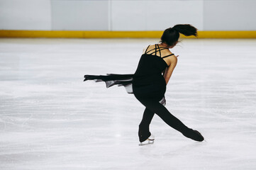 Patineuse artistique en train de faire une figure sur la glace - Sport dans la patinoire