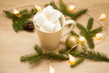 marshmallows in a mug. Christmas composition of fir branches and garlands