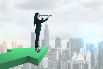 Businesswoman with spyglass standing on green arrow