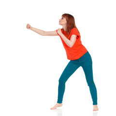 Barefoot Young Woman Clenches Her Fist. Side View.