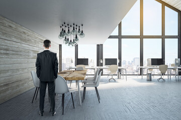 Businessman standing in coworking office interior