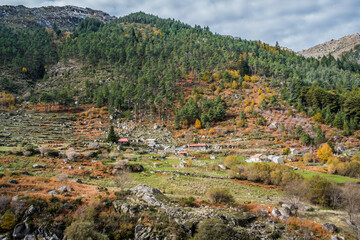 Fototapeta na wymiar Countryside landscape with fall colors, mountain with snow in the background, stone houses on the hill, Serra da Estrela Natural Park - Manteigas PORTUGAL