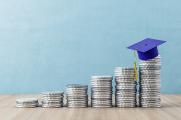 Stack of gold coins steps up and blue graduate hat