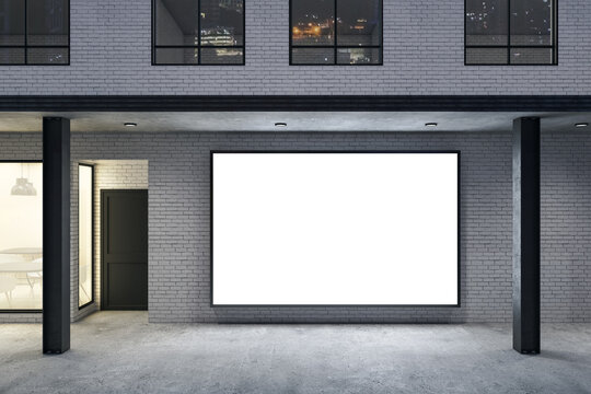 Store with blank poster on brick wall and columns.
