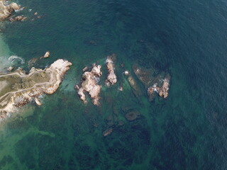 The coast view from the sky. Blue water and rocks. vertical or horizontal