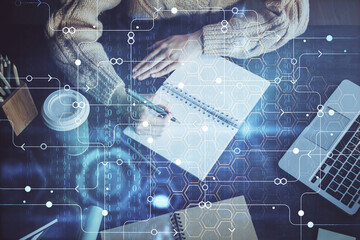 Double exposure of writing hands on background with data solution hologram on front. Technology...