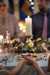 Close-up of hands holding together at the table at Christmas.