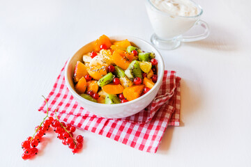 A bowl of fresh berry fruit salad on the white kitchen table. Vegan snack, diet food, healthy food concept.