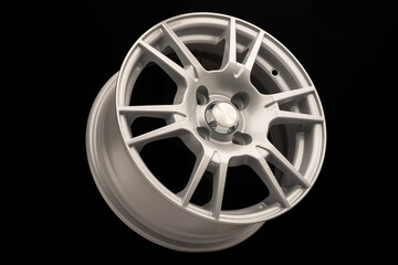 New silver alloy wheel on black background, side view