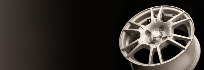 New silver alloy wheel on a black background,panoramic photo for the site header or advertising,...