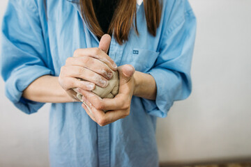 young woman, potter, makes utensils with their own hands in their own workshop