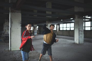Attack of teenage boys thugs in abandoned building, gang violence and bullying concept.