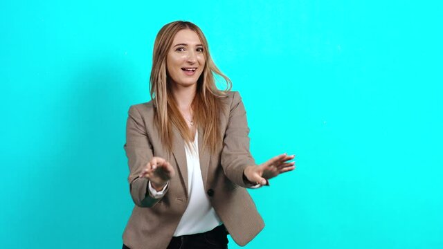 Happy young woman satisfied in business style suit proud of her victory, bragging with her wide smile pointing fingers at her, success. Studio image indoors, isolated on blue background