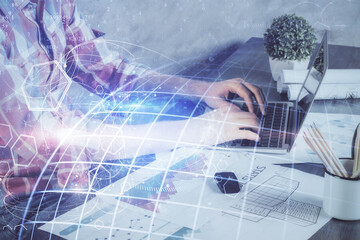 Double exposure of world map hologram with man working on computer on background. Concept of worldwideweb.