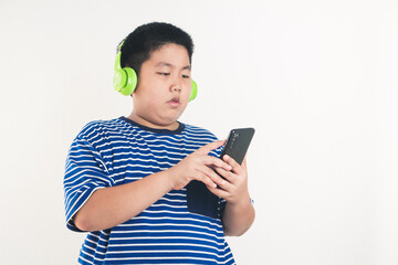 Asian fat boy standing playing smartphone Wearing headphones to music watching him happy. white...