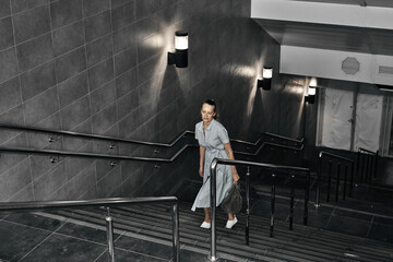 Girl on the stairs down, late transition, subway. One person on the descent into the underpass.