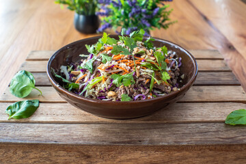 Asian beef salad with vegetables and nuts in a white bowl on a wood background Asian food concept