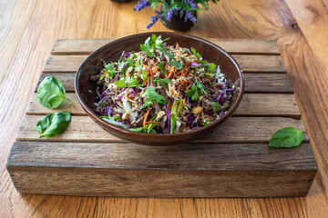 Asian beef salad with vegetables and nuts in a white bowl on a wood background Asian food concept