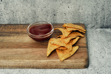 Corn cheese, snacks with sauce on a wooden stand. Beer snack, dish on the menu. Close up.
