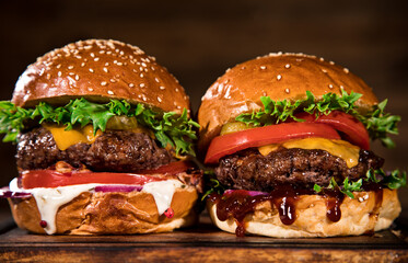 Close-up of home made tasty burgers on wooden table.