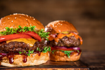 Close-up of home made tasty burgers on wooden table.