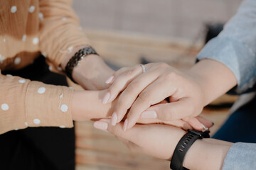 Two young adult lesbian women holding hands. Women's hands close up
