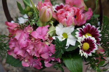 Obraz premium Composition from different flowers. Basket with daisies, tulips and other flowers