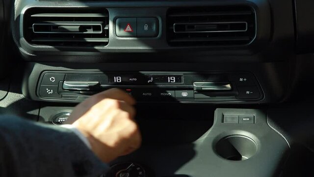 Car dashboard. The driver presses the buttons on the panel. Close-up