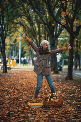 Teenage girl having fun in park on autumn day