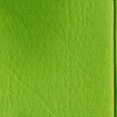 Obraz premium A green vintage rough sheet of carton. Recycled environmentally friendly cardboard paper texture. Simple and bright minimalist papercraft background.