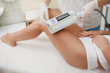 Beautician massaging legs of female client