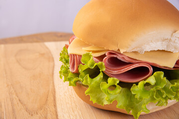 Mortadella, cheese and lettuce sandwiches, seen in detail on wooden surface, gray background, selective focus. © Milton Buzon