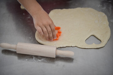 Kids playing with dough making homemade pastry products