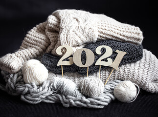 New year's composition with wooden numbers 2021 and sweaters background . The concept of cozy the...