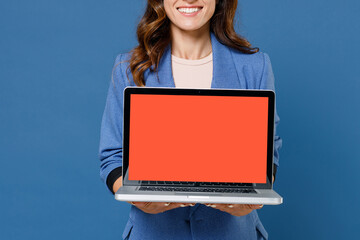Cropped image of smiling young brunette woman 20s wearing basic jacket hold laptop pc computer with blank empty screen mock up copy space isolated on bright blue colour background studio portrait.