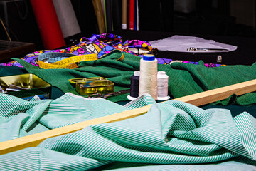 Mesa de costura con telas verdes hilo y accesorios de costura