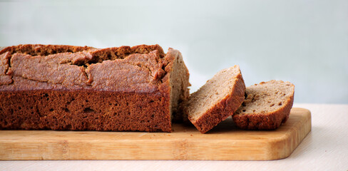 Homemade whole grain einkorn bread with two cut slices on a wooden board. Close up picture